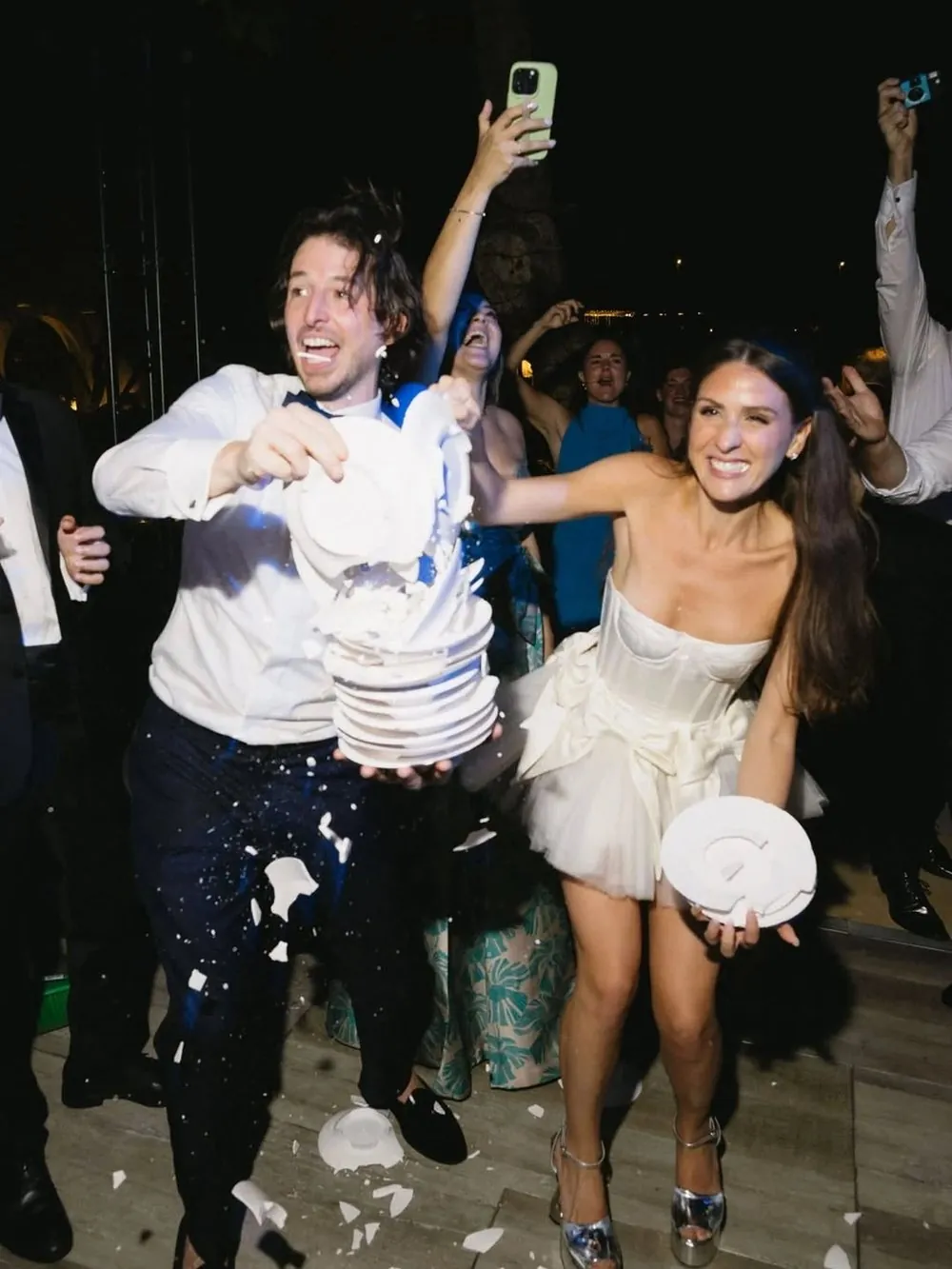 Ceremonia de boda al aire libre con el oficiante, los novios y los invitados bajo guirnaldas