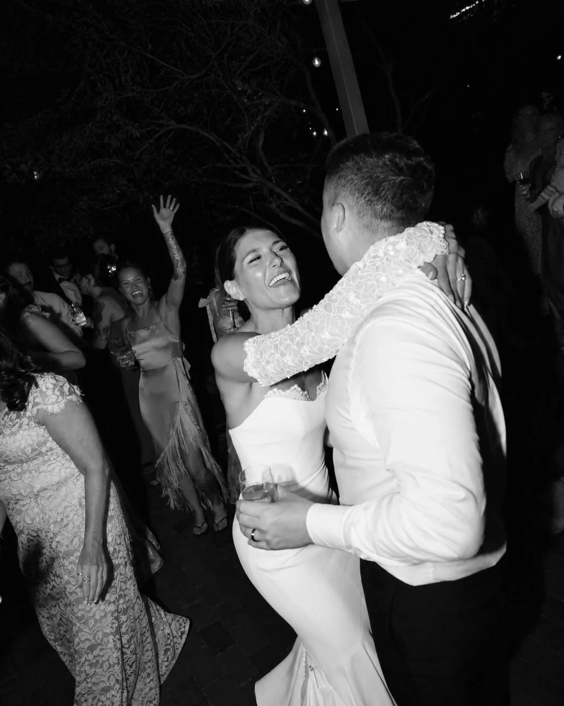 Los novios abrazados bailando en la pista mientras los invitados celebran
